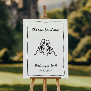 Cartel de bienvenida "Cheers to love", cartel de bienvenida a la boda dibujado a mano, tablero de bienvenida con copas de champán, ilustración escrita a mano y garabateada - HD1