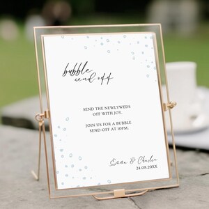 May include: A white sign with blue dots and the text "bubble send off" in black. The sign also includes the text "Send the newlyweds off with joy. Join us for a bubble send-off at 10pm." and the names "Emma & Charlie" with the date "24.08.20XX".
