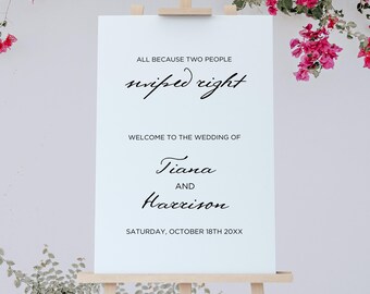 Puede incluir: Un letrero de bienvenida de boda blanco sobre un caballete de madera, con el texto "ALL BECAUSE TWO PEOPLE swiped right. WELCOME TO THE WEDDING OF Tiana AND Harrison. SATURDAY, OCTOBER 18TH 20XX." Flores rosas y follaje verde enmarcan el letrero.