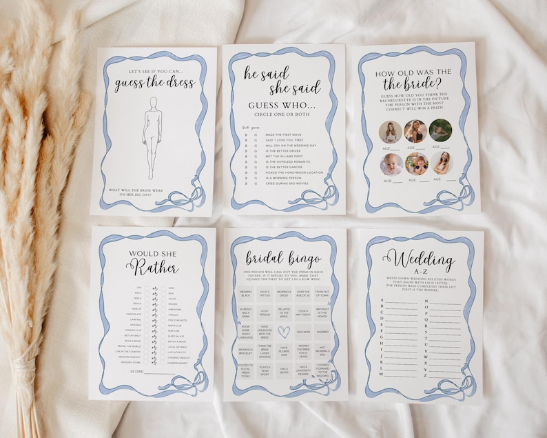 Op de afbeelding: Een set printbare bruidsdouche-spellen met blauwe en witte accenten. De spellen omvatten "Raad het jurkje", "Hij zei, zij zei", "Hoe oud was de bruid", "Zou ze liever", "Bruidsbingo" en "Bruiloft A-Z".