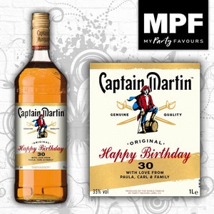 May include: A brown glass bottle with a gold label. The label features a pirate illustration and the text "Captain Martin" and "Original. Happy Birthday 30. With love from Paula, Carl & Family".