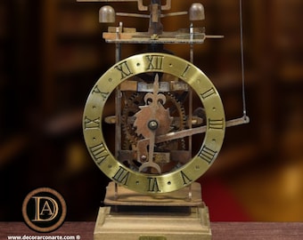 May include: A vintage-style clock with a brass face and Roman numerals. The clock is made of metal and has a wooden base. The clock has a bell on top and a pendulum hanging from the side.