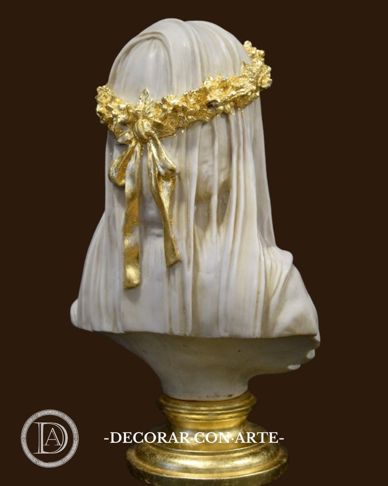 May include: White plaster bust of a woman wearing a gold leaf crown and veil. The bust is on a gold leaf base.