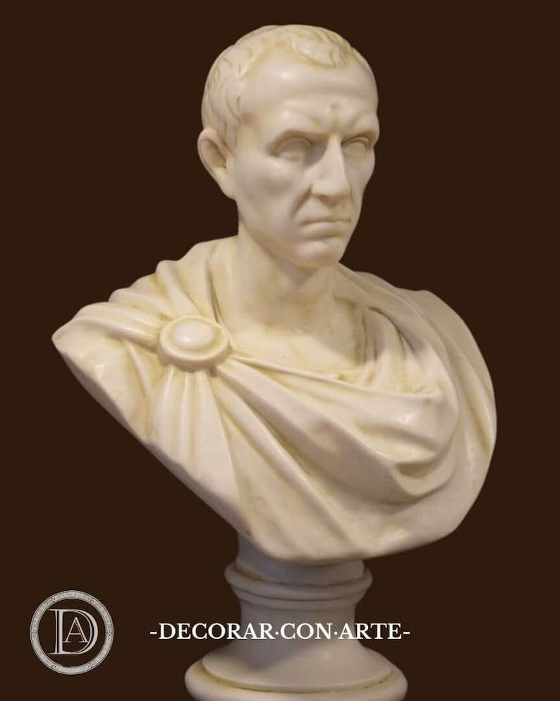 May include: A cream-coloured bust of a man with short hair and a stern expression. The sculpture features a draped garment fastened with a circular clasp. The bust is mounted on a pedestal. The text "-DECORAR.CON.ARTE-" is visible.