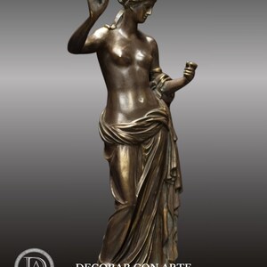 May include: Bronze sculpture of a woman in a flowing robe, holding a fruit in one hand and a cup in the other. The sculpture is on a square base.