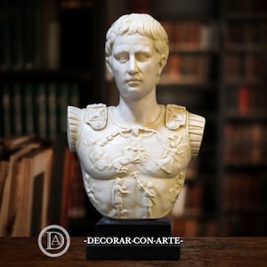 May include: A cream-colored bust of a Roman emperor, mounted on a black base. The bust features detailed carvings on the chest, depicting figures and scenes. The text "-DECORAR.CON.ARTE-" is visible at the bottom.