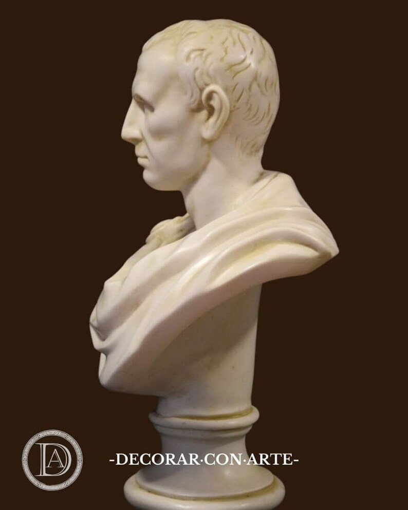 May include: A white marble bust of a man in profile, with detailed facial features and a draped garment. The sculpture is mounted on a pedestal. The bust is a classical art piece, with the text "-DECORAR.CON.ARTE-" in the lower left.
