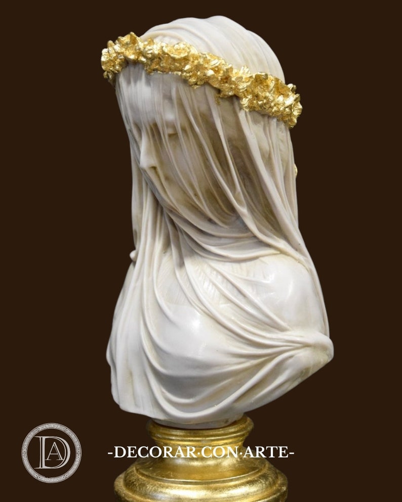 May include: A white marble bust of a woman wearing a veil and a gold leaf crown of flowers. The bust is on a gold-leafed wooden base.