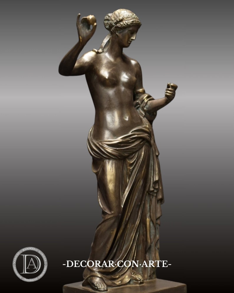 May include: Bronze sculpture of a woman standing with a draped garment, holding an apple in one hand and a cup in the other.