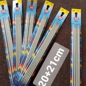 Könnte beinhalten: Satz mit sechs Stricknadeln in Größe 3,5 mm, jede 20-21 Zoll lang. Die Nadeln sind in bunten Plastikverpackungen verpackt, auf denen der Markenname "Unik" aufgedruckt ist.