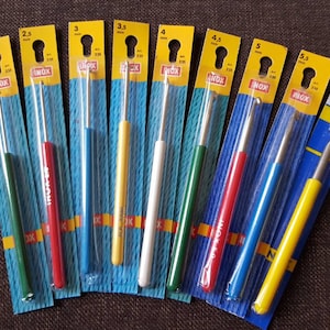 May include: A set of ten crochet hooks in various sizes, ranging from 2 mm to 6 mm. The hooks are packaged individually in clear plastic with yellow and blue packaging. The hooks are made of metal and have a silver finish. The packaging includes the size of the hook in millimeters.