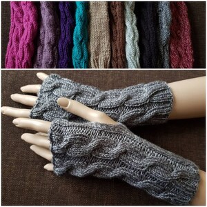 Könnte beinhalten: Graue Fingerlose Handschuhe mit einem Zopfmuster. Die Handschuhe sind aus einem weichen, warmen Garn.