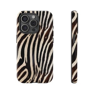 May include: A smartphone case featuring a black and white zebra stripe pattern. The case is shown from both the back, displaying the camera lens cutout, and the side profile, revealing the slim design and button placement on the edge.