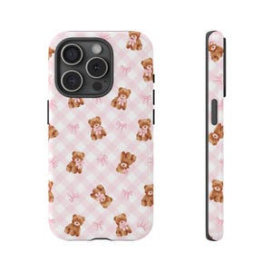 May include: A phone case featuring a repeating pattern of brown teddy bears with pink bows and pink bows on a pink and white checkered background. The case is shown from the front and side.