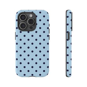 May include: A light blue phone case with a repeating pattern of dark blue polka dots. The case is shown from the front and side, highlighting its design and form. The case is designed to protect a smartphone.