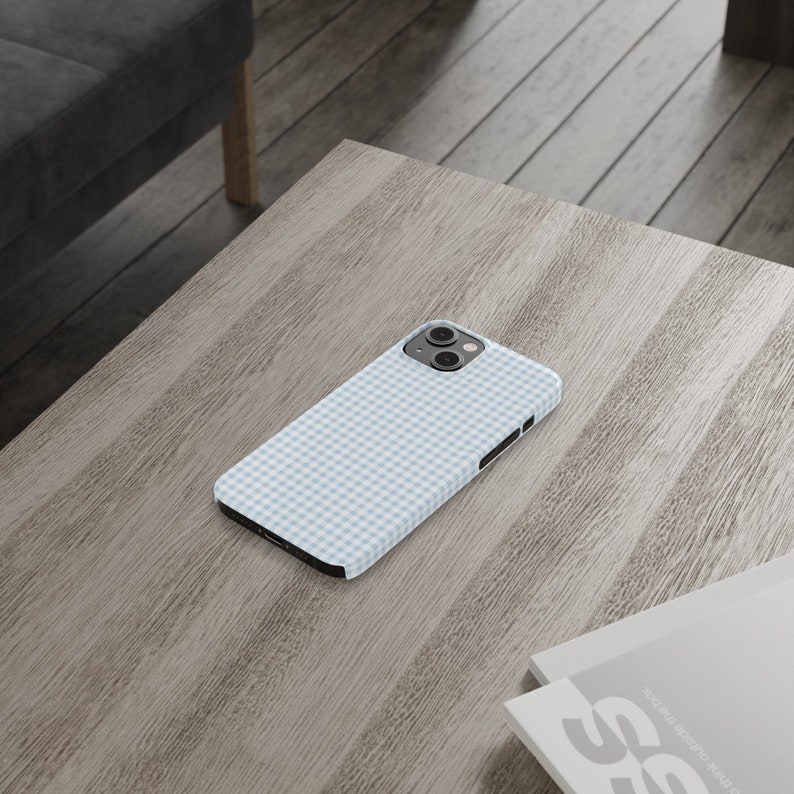 May include: A light blue and white gingham phone case for an iPhone.