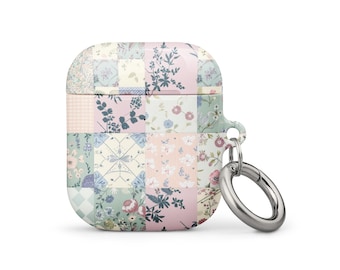 Può includere: Una custodia in silicone per AirPods con motivo floreale rosa e verde e un moschettone in metallo argentato.