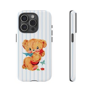 May include: A phone case featuring a vintage illustration of a teddy bear. The bear is light brown with a red heart and blue bow, set against a white background with blue vertical stripes. The case is white with black accents.