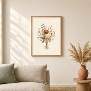 Könnte beinhalten: Ein gerahmter Kunstdruck mit einer Aquarellillustration eines Trockenblumenstraußes. Das Arrangement besteht aus rostfarbenen Chrysanthemen, beigem Pampasgras und salbeigrünen Eukalyptusblättern, die mit einer einfachen Schnur zusammengebunden sind.