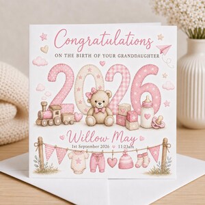 May include: A square greeting card featuring the text Congratulations ON THE BIRTH OF YOUR GRANDDAUGHTER, the year 2026, a teddy bear, a toy train, baby blocks, a bottle, a pacifier, the name Willow May, and the date 1st September 2026.