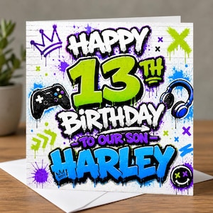 May include: A square birthday greeting card featuring graffiti-style text that reads HAPPY 13TH BIRTHDAY TO OUR SON HARLEY. The design includes a black game controller, blue headphones, a purple crown, and a smiley face on a white brick background.