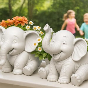 May include: Two smiling white elephant planters, each holding flowers. One has its trunk raised. The planters sit on a windowsill with a blurred background of children playing outside. The flowers are orange and white.
