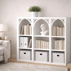 May include: A white bookcase with arched detailing, containing books, binders, and storage boxes. A small potted plant and a classical bust are displayed. The room has a neutral colour palette.