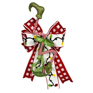 May include: A red and white checkered bow with a green and white striped elf leg and a green and white string of lights.