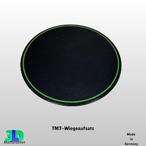 Könnte beinhalten: Ein schwarzes, kreisförmiges Objekt mit einem grünen Rand. Der Text "TM7-Wiegeaufsatz" ist unten aufgedruckt. Das Logo von "3D Manufaktur" befindet sich in der unteren linken Ecke, und "Made in Germany" steht unten rechts.
