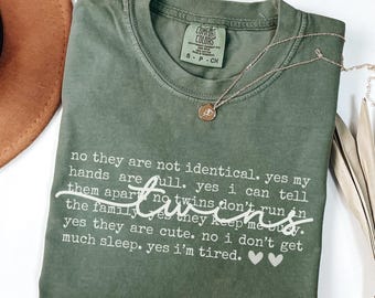 May include: A green t-shirt with white text that reads "no they are not identical. yes my hands are full. yes i can tell them apart no twins don't run in the family yes they keep me busy. yes they are cute. no i don't get much sleep. yes i'm tired."