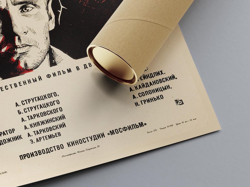 May include: A black and white poster for the film "Stalker" with the names of the cast and crew listed in Russian. The poster is rolled up and tied with a brown ribbon.