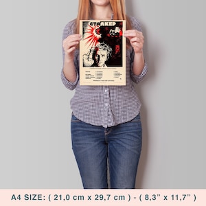 May include: A vintage-style poster for the film "Stalker" featuring a man's face with a crown of thorns and a red sunburst in the background. The poster is printed on a cream-colored paper with black and red text. The poster measures 8.3 inches by 11.7 inches.