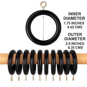 May include: Black curtain rings with gold-colored hooks, displayed on a wooden rod. The inner diameter is 1.75 inches (4.45 cm), and the outer diameter is 2.5 inches (6.35 cm). One ring is shown separately with a measurement arrow.