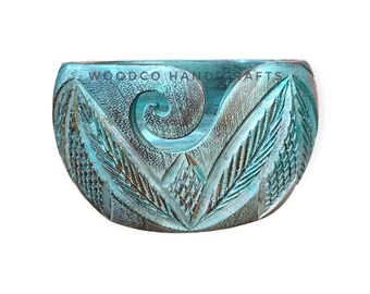 Könnte beinhalten: Tealblaue Holz-Garn-Schale mit einem geschnitzten Blattdesign und einer spiralförmigen Rille für Garn. Die Schale ist handgefertigt und hat eine rustikale Oberfläche. "WOODCO HANDICRAFTS" steht auf der Seite der Schale.