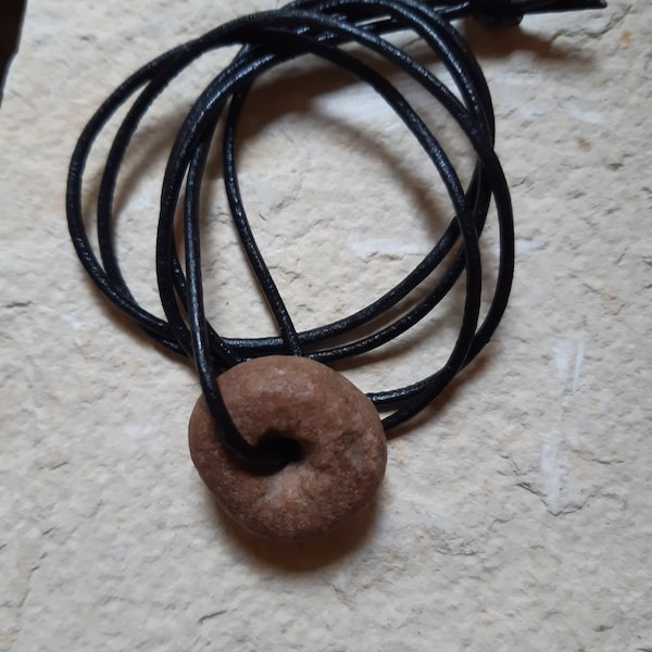 A single ancient calcite Neolithic bead, Saharan find on knotted leather