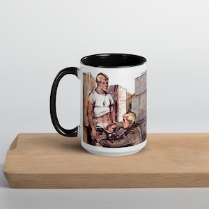 Può includere: Tazza in ceramica bianca con bordo e manico neri. La tazza presenta un'illustrazione in bianco e nero di due uomini in un contesto urbano. Uno degli uomini indossa una camicia bianca e l'altro una giacca marrone.