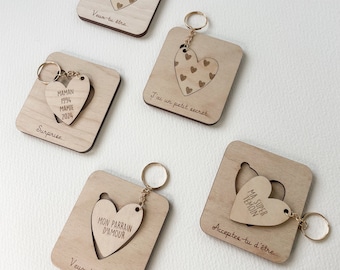 May include: Set of five wooden keychains with a heart-shaped cutout. Each keychain features a different message, including "Veux-tu être...", "J'ai un petit secret...", "Surprice...", "Acceptes-tu d'être...", and "Veux-tu être..."