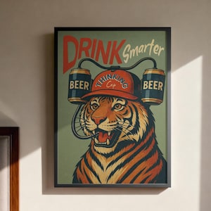 May include: Framed art print. A tiger wearing a red cap with the words "Thinking Cap." Beer cans are attached to the cap with the word "Beer" on them. The print has the words "Drink Smarter" at the top. The artwork has a vintage style.