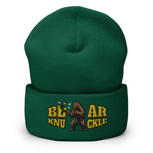 May include: Green beanie with a brown bear knuckle punching graphic and the text "Bear Knuckle" in yellow.