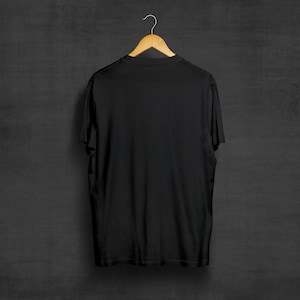 May include: A black t-shirt hanging on a wooden hanger against a dark gray background.