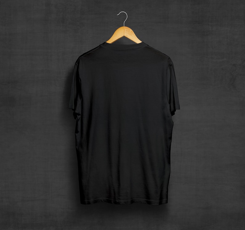 May include: A black t-shirt hanging on a wooden hanger against a dark gray background.