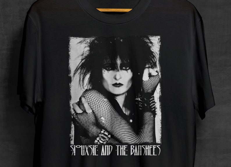May include: Black and white graphic t-shirt featuring a photo of Siouxsie Sioux, lead singer of Siouxsie and the Banshees, with the band's name printed below the image.