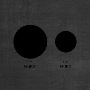 Op de afbeelding: Twee zwarte cirkels op een grijze achtergrond. De grotere cirkel heeft een diameter van 2,25 inch. De kleinere cirkel heeft een diameter van 1,25 inch.