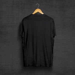 May include: A black t-shirt hanging on a wooden hanger against a dark gray background.
