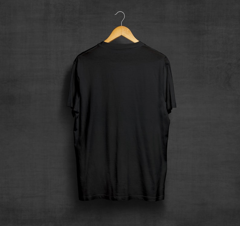 May include: A black t-shirt hanging on a wooden hanger against a dark gray background.