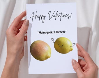 May include: A white Valentine's Day card with the text "Happy Valentines!" in cursive. The card features two lemons, one with a smiling face and arms, and the phrase "Main squeeze forever".
