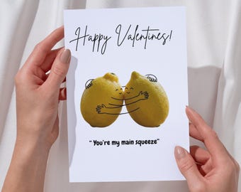 May include: A Valentine's Day card with the text "Happy Valentines!" in a handwritten font. The card features two cartoon lemons hugging, with the phrase "You're my main squeeze" below.