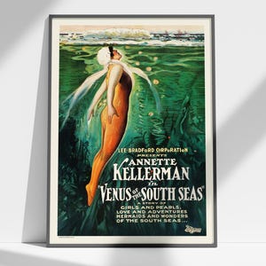 May include: Vintage poster in a black frame featuring Annette Kellerman in "Venus of the South Seas." The artwork depicts a woman in an orange swimsuit underwater, with text about girls, pearls, love, and mermaids. The poster has a green and blue color scheme.
