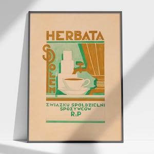 May include: Framed vintage Polish tea advertisement. The poster features the word "HERBATA" in brown letters above a green and brown illustration of a tea cup and teapot. The text "ZWIĄZKU SPÓŁDZIELNI SPOŻYWCÓW R.P" is at the bottom.