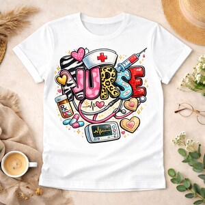 Op de afbeelding: Wit T-shirt met een kleurrijk grafisch ontwerp met het woord "NURSE". Het ontwerp bevat medische illustraties zoals een spuit, stethoscoop, pillen en een hartmonitor. De letters hebben een zebra- en luipaardprint.